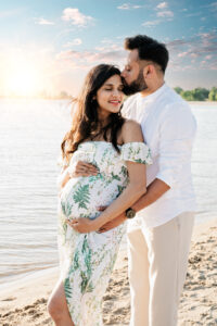 Zwangerschapsshoot op het strand met romantische dubbele belichting van verliefd stel in boho stijl
