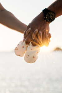 Zwangerschapsshoot op het strand met romantische dubbele belichting van verliefd stel in boho stijl