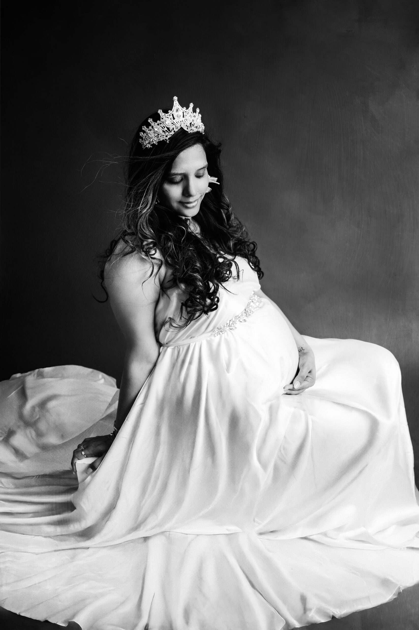 Zwangerschapsshoot Almere | Elegante Maternity Foto’s Zwangere vrouw in witte, golvende stof tijdens artistieke zwangerschapsshoot in studio Almere