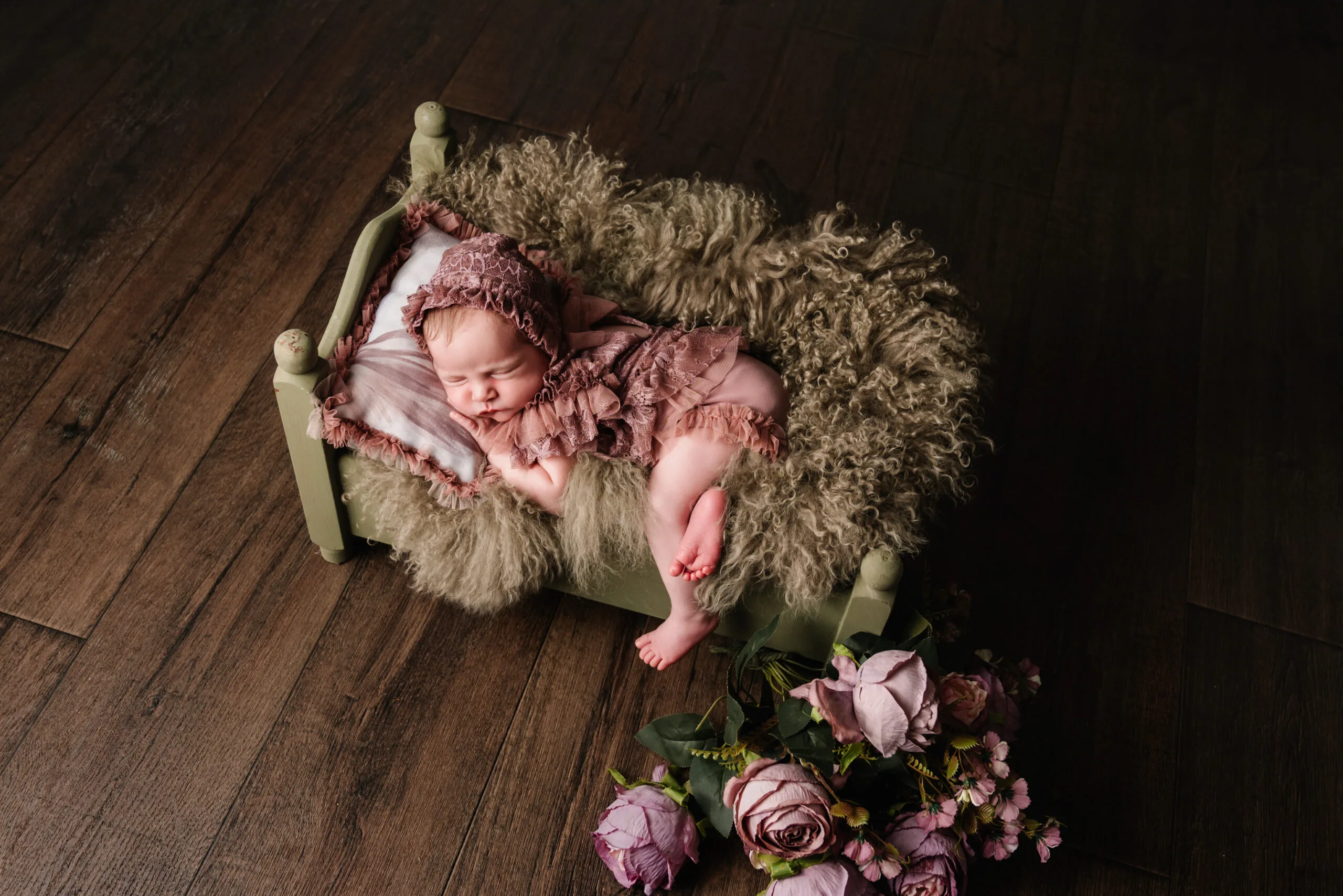 Newborn fotoshoot in Almere – veilige en professionele fotografie Pasgeboren baby in een witte doek hanger, veilig gefotografeerd door gecertificeerde newborn fotograaf in Almere
