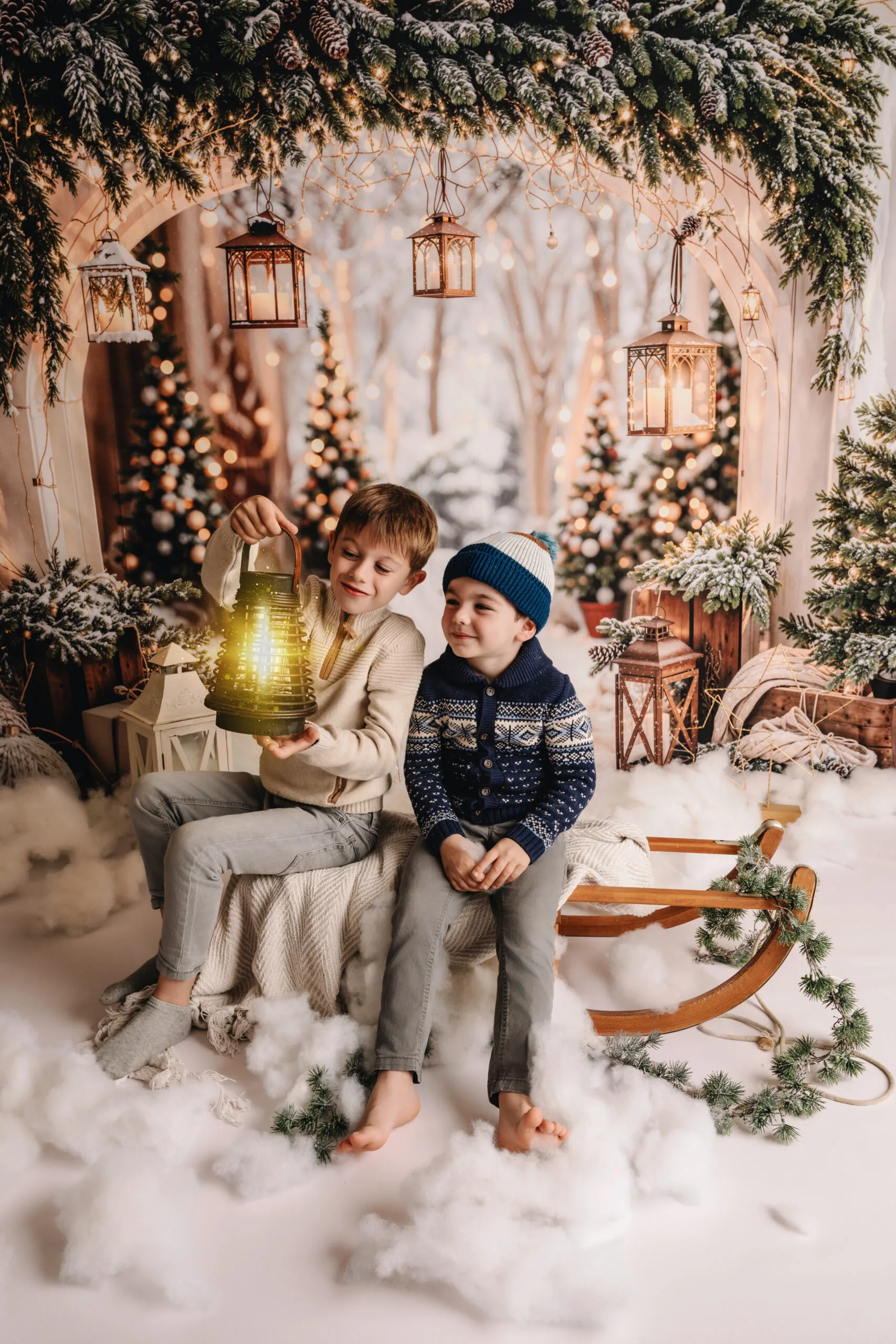 Twee jonge jongens in winterkleding op een slee in een knus kerstdecor met gloeiende lantaarns en feestelijke versiering